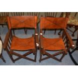 A pair of folding mahogany Director chairs with slung leather seats and backs