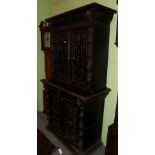 A Victorian carved oak bookcase, elaborately carved to the borders, with mask and floral decoration,
