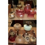 Three oil lamp bases and a collection of etched and other cranberry and clear glass shades etcSome