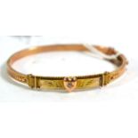 A 9 carat gold hinged bangle with diamond set heart motif and thistle decoration. Gross weight 6.