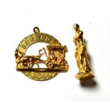 A charm/pendant of the Venus de Milo stamped 'K18'; and a pendant depicting a horse and carriage