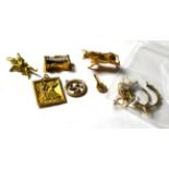 Six unmarked charms/pendants including a bull, a key etc; together with two 9 carat gold pendant
