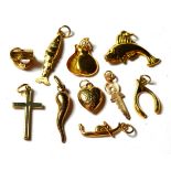 Four 9 carat gold charms including a fish, a cross, a wishbone etc; two charms stamped '9CT'
