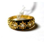 An 18 carat gold black enamelled three stone mourning ring, finger size K1/2. Gross weight 2.6