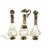 Three Dutch silver-mounted glass bottles, each with differing hinged cover and engraving, one with