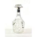 A cut glass decanter with silver collar