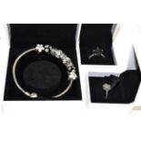 Two Pandora rings, finger sizes Q and S; and a Pandora charm bracelet with nine charms, all