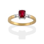 An 18 Carat Gold Ruby and Diamond Three Stone Ring, the modified emerald-cut ruby sits between two