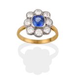 A Sapphire and Diamond Cluster Ring, the cushion cut sapphire within a border of round brilliant cut