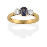 An 18 Carat Gold Sapphire and Diamond Three Stone Ring, the oval cut green sapphire between two