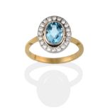 An Aquamarine and Diamond Cluster Ring, the oval cut aquamarine in a white rubbed over setting,