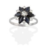 A Sapphire and Diamond Cluster Ring, a round brilliant cut diamond centres a cluster of six marquise