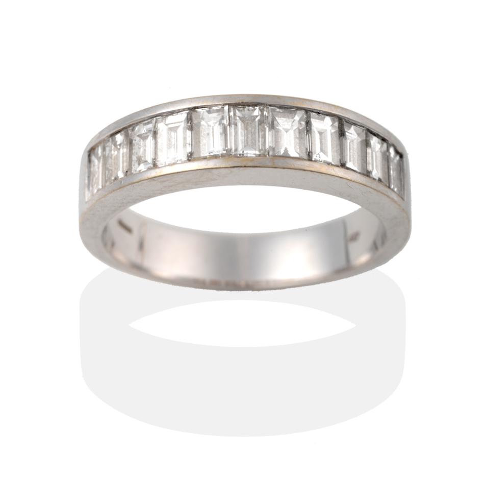 An 18 Carat White Gold Half Hoop Ring, eleven graduated baguette cut diamonds in a channel