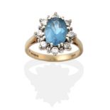 A 9 Carat Gold Blue Topaz and Diamond Cluster Ring, the oval cut blue topaz in a white double claw