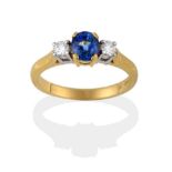 An 18 Carat Gold Sapphire and Diamond Three Stone Ring, the oval mixed cut sapphire between two