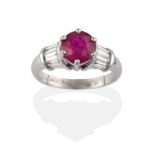 An 18 Carat White Gold Ruby and Diamond Ring, a round cut ruby claw set with tapered baguette cut