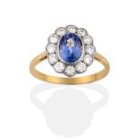 A Sapphire and Diamond Cluster Ring, the oval cut sapphire within a border of twelve round brilliant