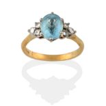 An 18 Carat Gold Aquamarine and Diamond Ring, the oval cut aquamarine flanked by a trio of
