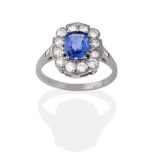 A Sapphire and Diamond Cluster Ring, the cushion cut sapphire within a border of round brilliant cut