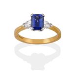 An 18 Carat Gold Sapphire and Diamond Three Stone Ring, the emerald-cut sapphire flanked by two pear