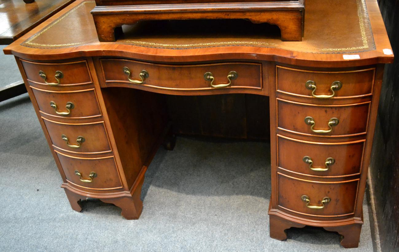 Reproduction yew wood serpentine shaped desk, 115cm wide