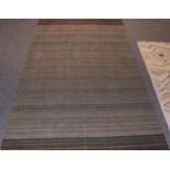 Modernist Rug, The abrashed green field with narrow polychrome bands, 247cm by 153cm. In excellent
