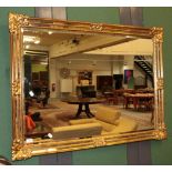 A reproduction gilt bevel glass mirror 89cm by 113cm