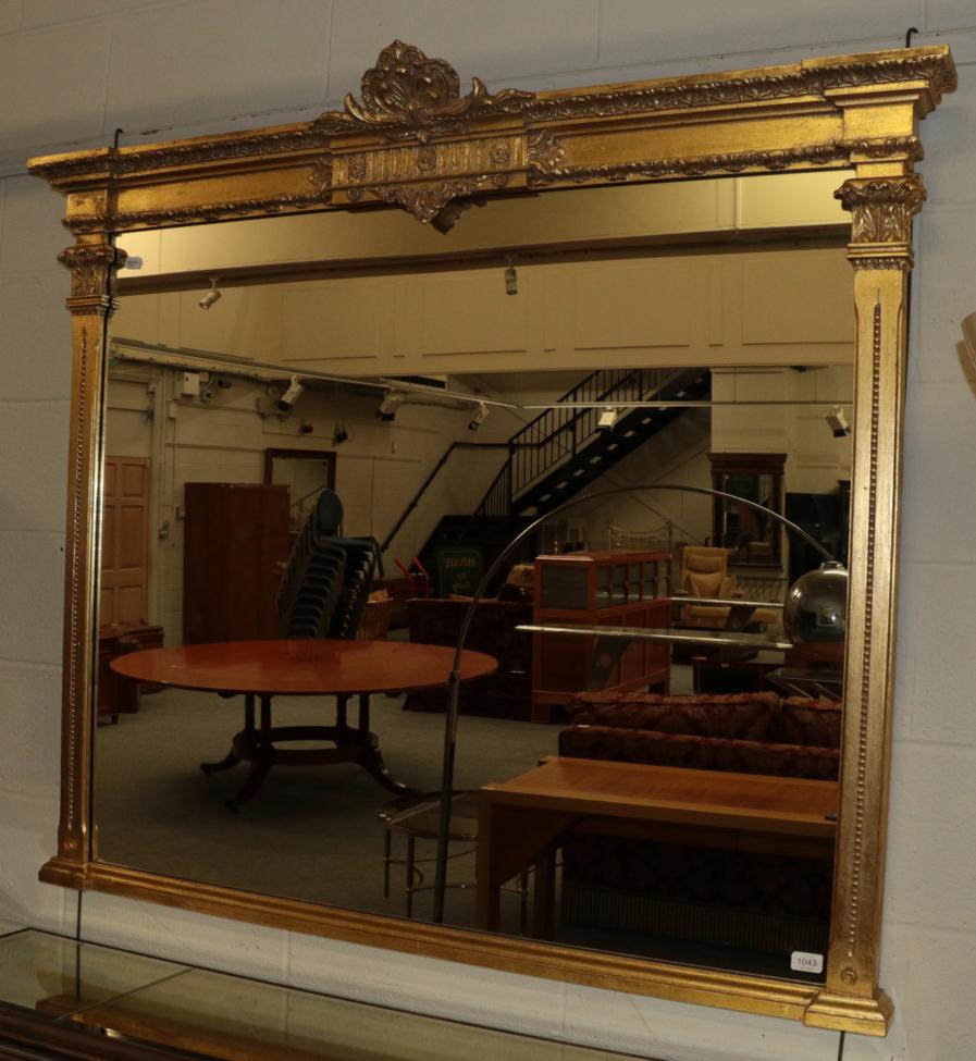 A Gilt Overmantel Mirror, in the Victorian style, the plain mirror plate surmounted by a decorate