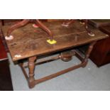 A 17th century oak rectangular table with turned legs and block feet joined by a stretcher, 152cm by