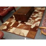 Hides/Skins: A Large Patchwork Cow Hide Rug, modern, constructed with square sections of cow hide in