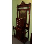 A reproduction hardwood hall stand, in the Victorian Style, with bevel glass mirror and four brass
