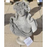 A large weathered composition bust of a classical female on a circular socle, with a sectional