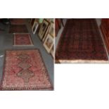 ^ A Baluch rug, the midnight blue field with eight panels enclosed by slant leaf borders, 197cm by