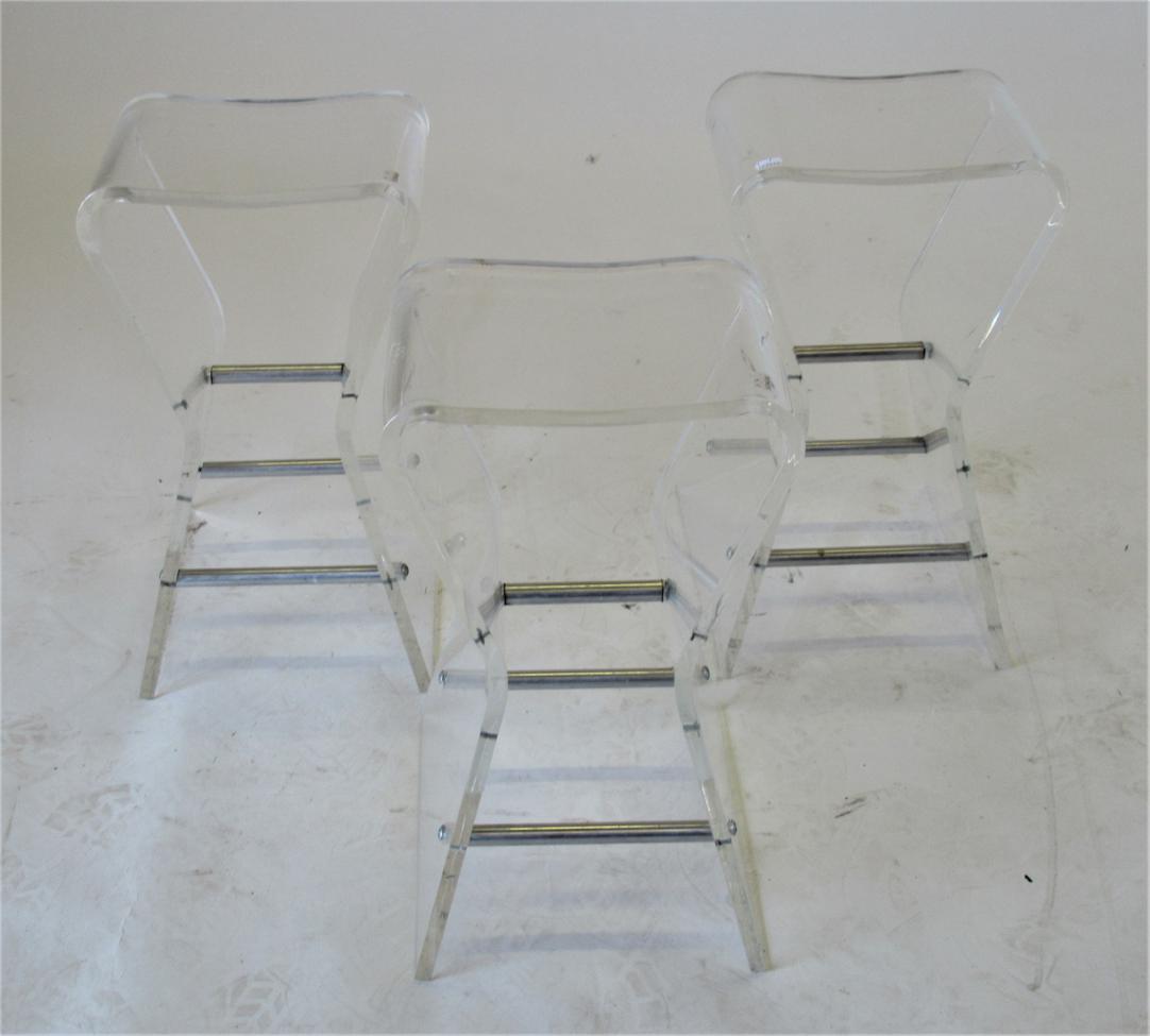 A Set of Three Late 20th Century Clear Plastic Side Tables, the splayed legs joined by tubular