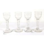 A Set of Four Wine Glasses, circa 1790, the ovoid bowls engraved with swags, on faceted stems and