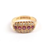 An 18 Carat Gold Ruby and Diamond Ring, 1905, a row of five graduated round faceted rubies flanked