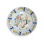An English Delft Dish, probably Vauxhall, circa 1730, painted in colours with a cockerel in a fenced