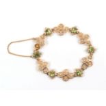 An Early 20th Century Peridot and Seed Pearl Bracelet, quatrefoil links of circular disks with a