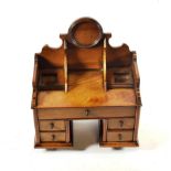 A Walnut Inkstand, mid 19th century, in the form of a kneehole dressing table, with shaped