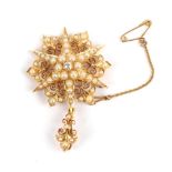 A Diamond and Seed Pearl Brooch/Pendant, circa 1910, a central star form with decorative panels of