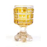 A Bohemian Amber Overlay Clear Glass Spa Goblet, late 19th century, engraved with views and