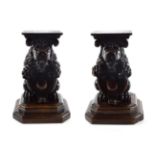 A Pair of Carved Walnut Stands, in 16th century style, as seated lions holding armorials, 25cm high