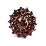 A Garnet Cluster Ring, with three rows of rose cut garnets, in yellow claws, on a plain polished