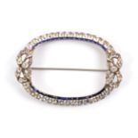 A Blue and White Faceted Paste Brooch, the oval form with a white paste set bow at each end, the