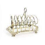 A George IV Silver Toast-Rack, by Thomas and John Settle, Sheffield, 1820, the seven bars on scroll,