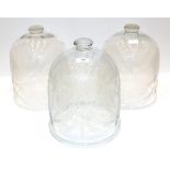 A Set of Three Glass Cloches, of domed form, engraved with stylised foliage, 40cm high
