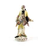 A Bow Porcelain Figure of a Gentleman, circa 1760, standing wearing a yellow coat, his hat under his