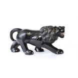 A South East Asian Ivory and Ebonised Model of a Lion, 37cm long