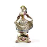 A Bow Porcelain Figure of a Dancing Girl, circa 1765, wearing a yellow hat and pink bodice, on a