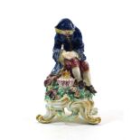 A Bow Porcelain Figure of Winter, circa 1765, as a bearded figure seated beside a brazier, on a tall